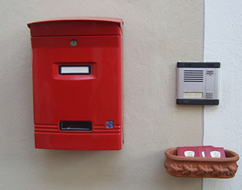 Roter Briefkasten mit Klingel und Ablage