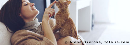 Eine Frau spielt mit ihrer Katze auf dem Sofa